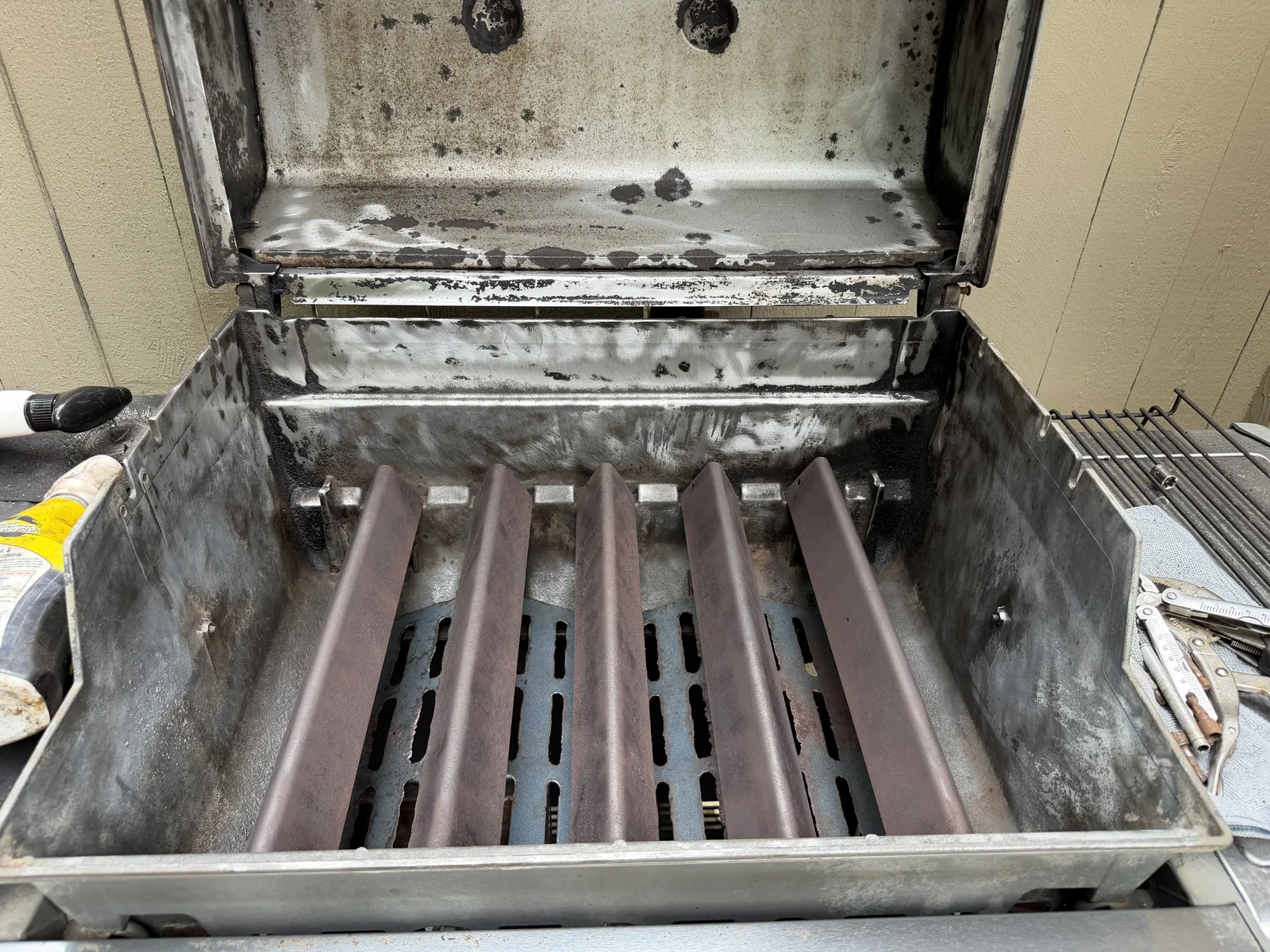 After: the same cookbox cleaned down to bare metal — flavorizer bars and firebox walls scrubbed clear