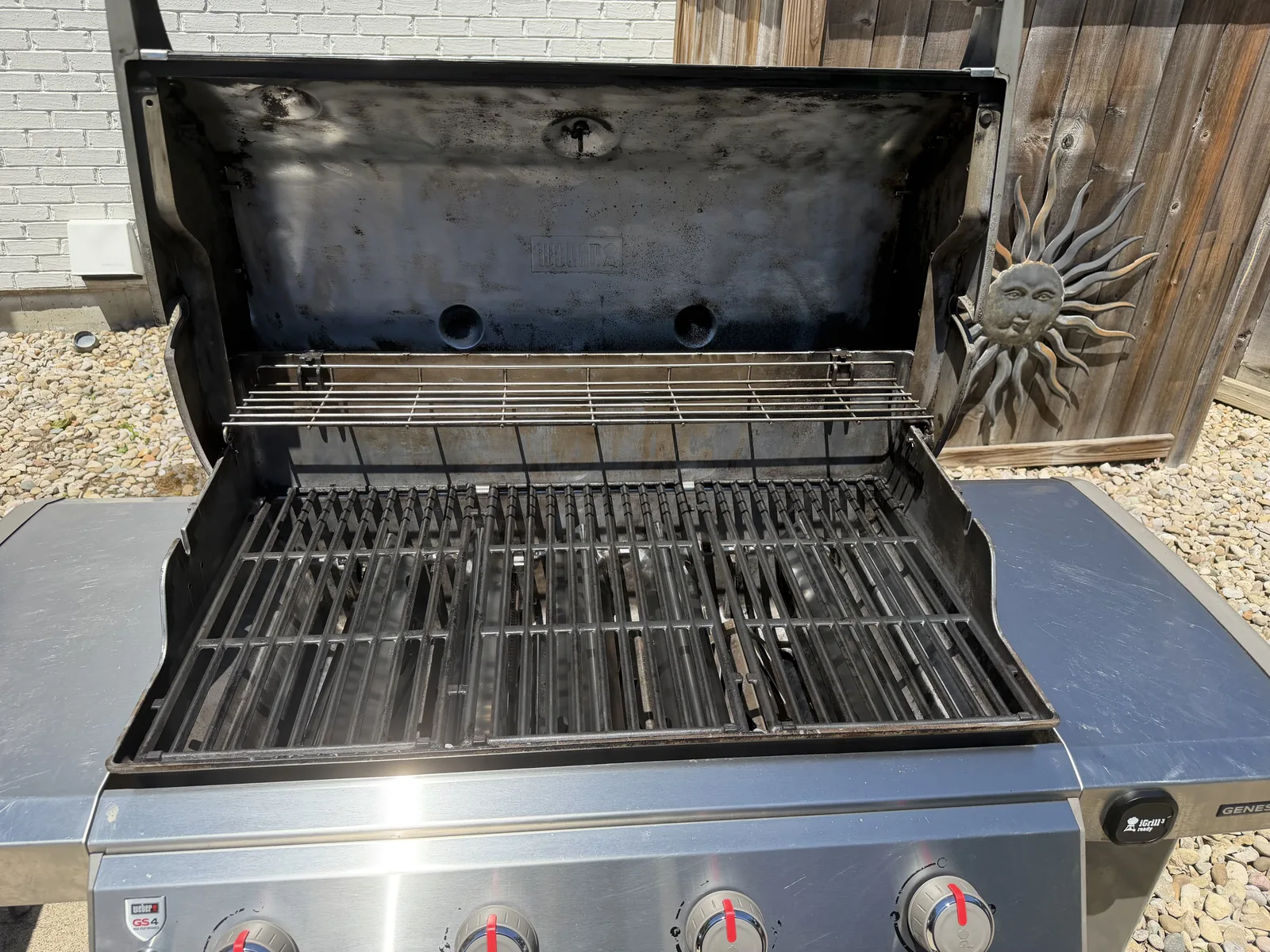 After: the same Weber Genesis II with clean grates reinstalled, the warming rack in place, and a wiped-down cookbox — ready to cook